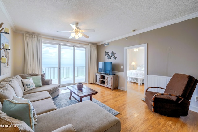10519 Front Beach Rd Unit 1801A, Panama City Beach, FL 32407 - living area featuring ceiling fan, light wood finished floors, crown molding, a textured ceiling, and wainscoting