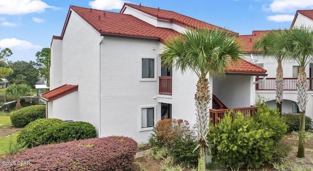 view of property exterior featuring a tile roof and stucco siding