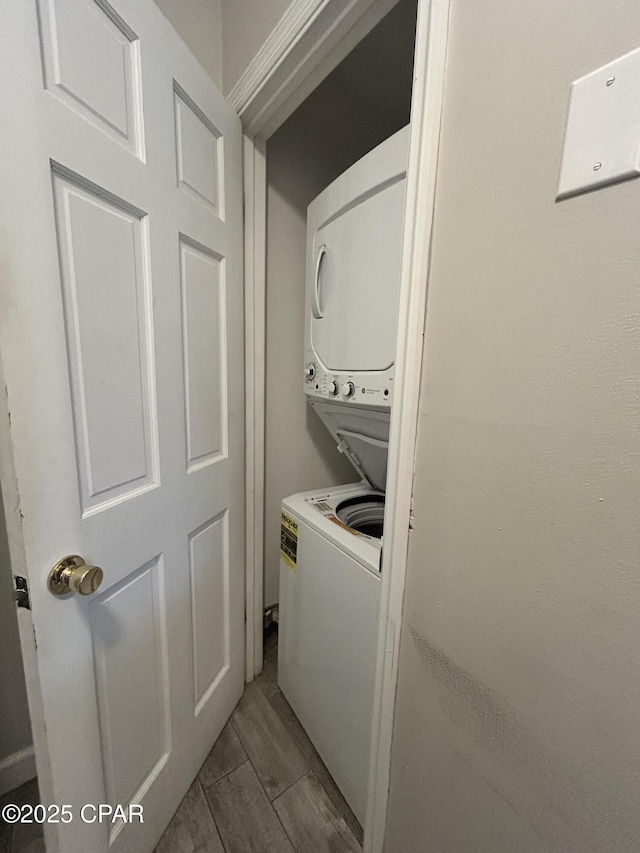 clothes washing area featuring stacked washer and clothes dryer