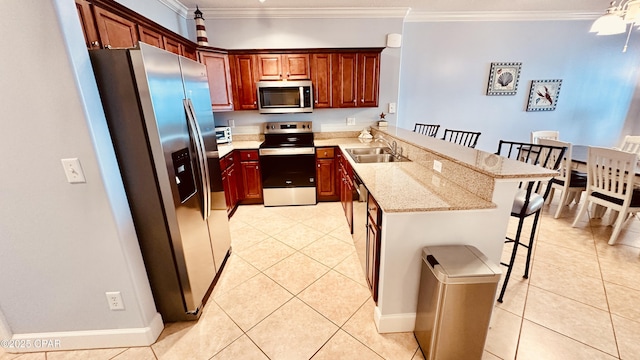 17643 Front Beach Rd Unit 1704, Panama City Beach, FL 32413 - kitchen with stainless steel appliances, a peninsula, a sink, a breakfast bar area, and crown molding