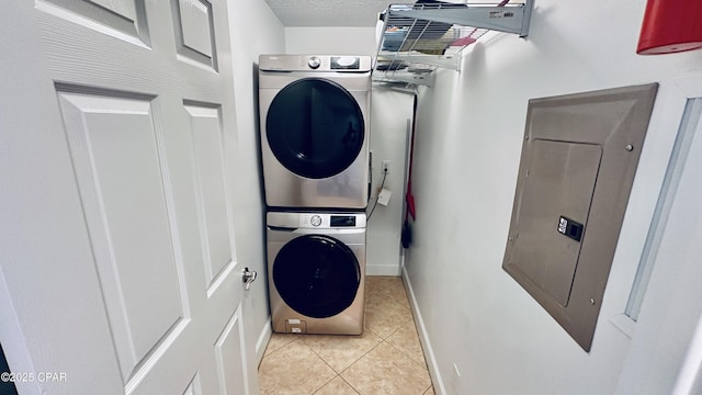 17643 Front Beach Rd Unit 1704, Panama City Beach, FL 32413 - washroom featuring stacked washer and clothes dryer, light tile patterned floors, baseboards, and electric panel