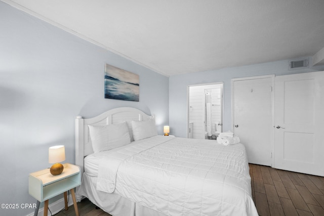 8743 Thomas Dr Unit 1211, Panama City Beach, FL 32408 - bedroom featuring dark wood-type flooring, ornamental molding, and connected bathroom