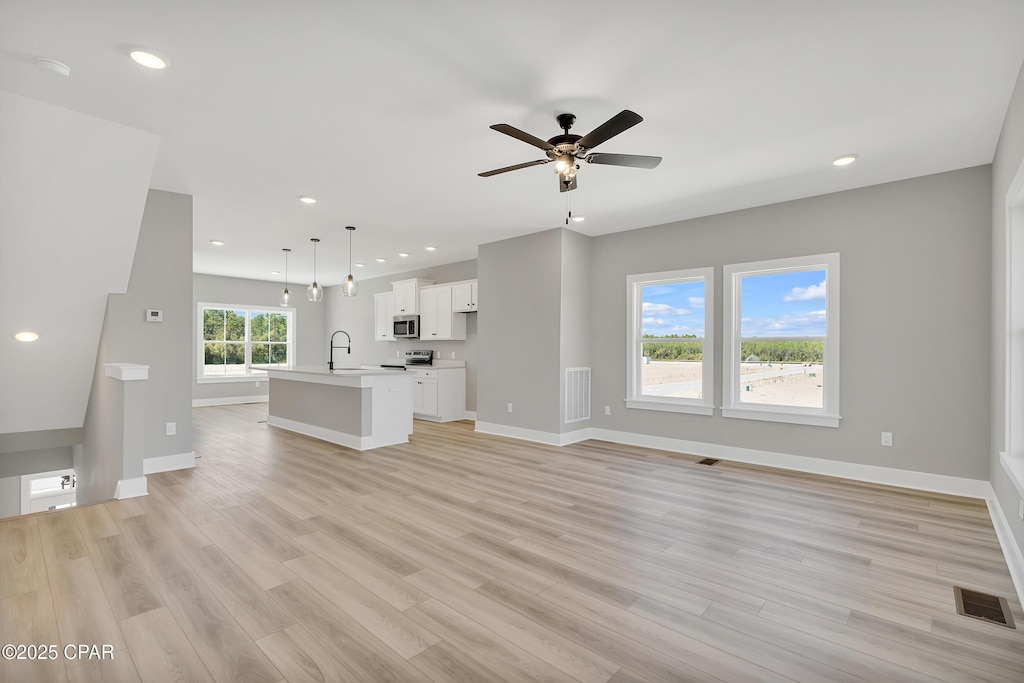 314 Lapis Ln Unit 169, Panama City Beach, FL 32407 - unfurnished living room with a sink, ceiling fan, light wood-style flooring, baseboards, and recessed lighting