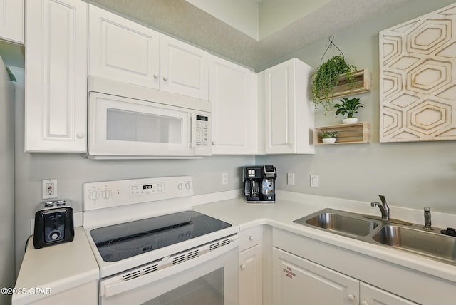 1515 SE Miracle Strip Pkwy Unit 609, Fort Walton Beach, FL 32548 - kitchen with white appliances, a sink, white cabinetry, and light countertops
