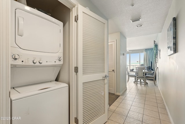 1515 SE Miracle Strip Pkwy Unit 609, Fort Walton Beach, FL 32548 - laundry room with stacked washer and clothes dryer, baseboards, and a textured ceiling
