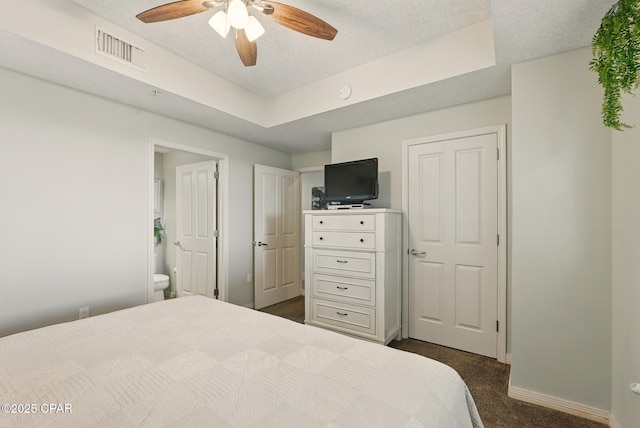 1515 SE Miracle Strip Pkwy Unit 609, Fort Walton Beach, FL 32548 - bedroom with baseboards, dark colored carpet, a textured ceiling, ensuite bath, and a ceiling fan