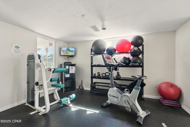 1515 SE Miracle Strip Pkwy Unit 609, Fort Walton Beach, FL 32548 - exercise area featuring a textured ceiling and baseboards