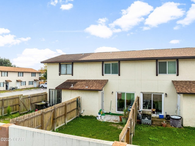 710 Legion Dr Unit O4, Destin, FL 32541 - back of house featuring stucco siding, a shingled roof, and a gate