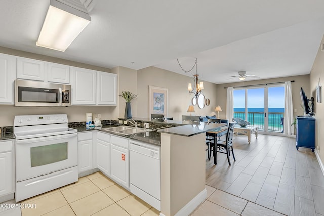 15817 Front Beach Rd Unit 2-2108, Panama City Beach, FL 32413 - kitchen featuring white appliances, a peninsula, dark countertops, white cabinets, and a ceiling fan