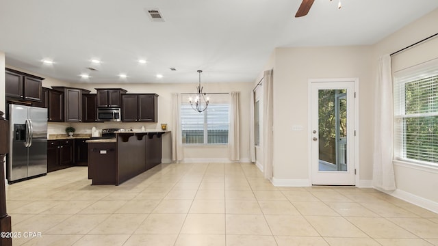 76 Mosaic Oaks Cir, Santa Rosa Beach, FL 32459 - kitchen with stainless steel appliances, a ceiling fan, a chandelier, dark brown cabinets, and baseboards