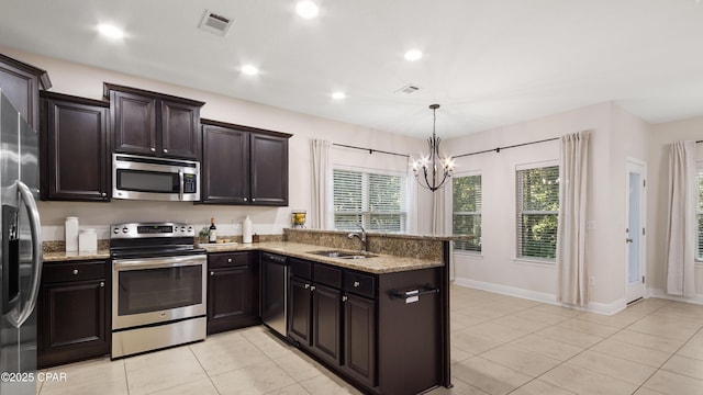 76 Mosaic Oaks Cir, Santa Rosa Beach, FL 32459 - kitchen with stainless steel appliances, a sink, light stone counters, a chandelier, and recessed lighting