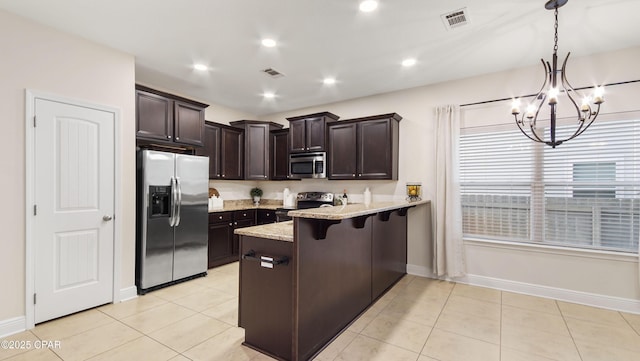 76 Mosaic Oaks Cir, Santa Rosa Beach, FL 32459 - kitchen with stainless steel appliances, dark brown cabinetry, a peninsula, a breakfast bar area, and baseboards