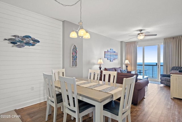 14825 Front Beach Rd Unit 2210, Panama City Beach, FL 32413 - dining area featuring wood finished floors, a ceiling fan, a water view, a chandelier, and wood walls