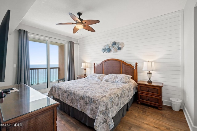 14825 Front Beach Rd Unit 2210, Panama City Beach, FL 32413 - bedroom featuring access to exterior, a water view, dark wood-style flooring, wood walls, and baseboards