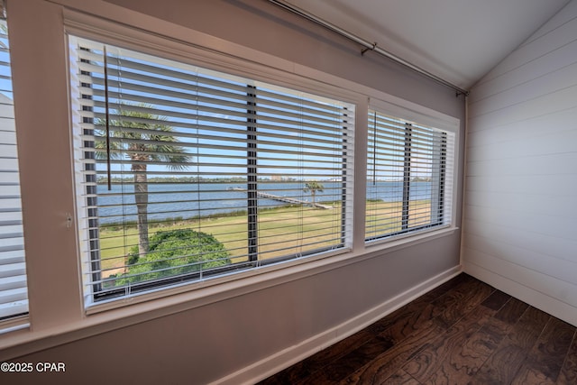 detailed view of a water view, wood finished floors, baseboards, and wooden walls
