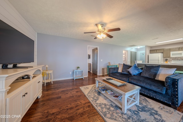 living area featuring dark wood finished floors, a ceiling fan, a textured ceiling, and baseboards