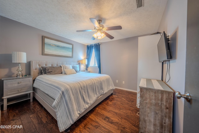 bedroom featuring a textured ceiling, dark wood finished floors, baseboards, and ceiling fan