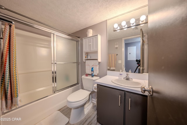 full bathroom featuring a textured ceiling, toilet, vanity, combined bath / shower with glass door, and wood finished floors