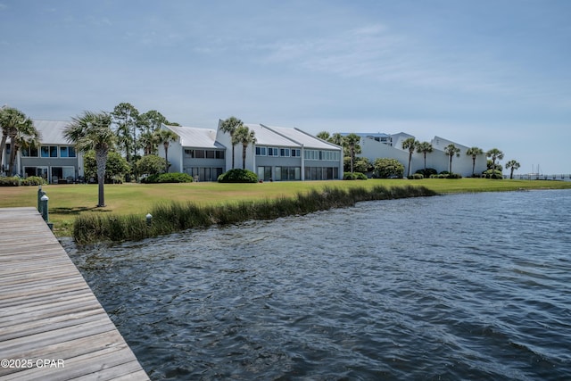 dock area with a water view, a residential view, and a lawn