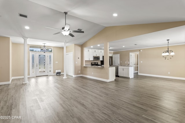 468 Forest Shore Dr, Miramar Beach, FL 32550 - unfurnished living room with vaulted ceiling, wood finished floors, a chandelier, baseboards, and decorative columns