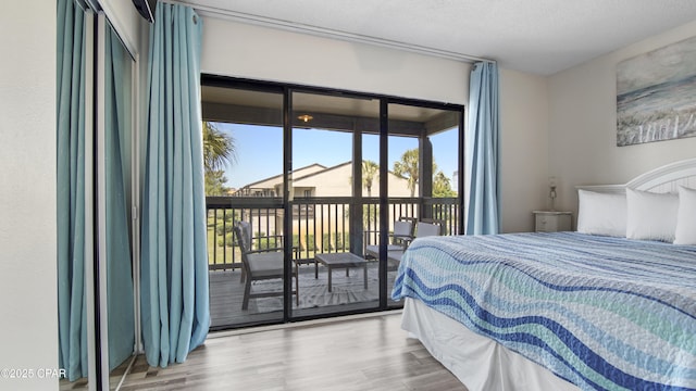 bedroom with wood finished floors and access to outside