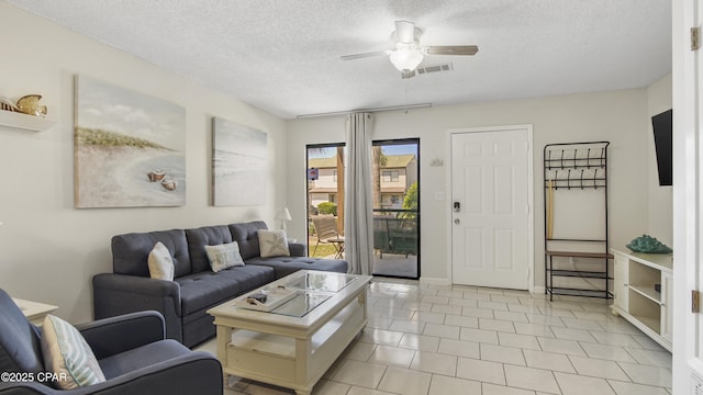 living area with a ceiling fan, a textured ceiling, and light tile patterned floors