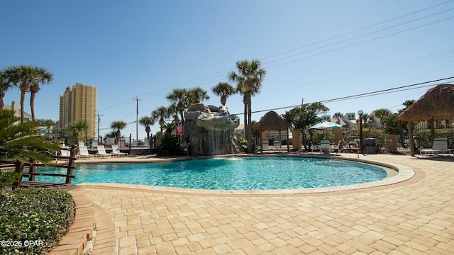 community pool with a gazebo, fence, and a patio area