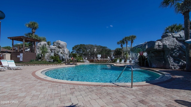 community pool with a patio and fence