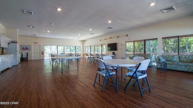 dining area with dark wood-style floors, recessed lighting, and a textured ceiling