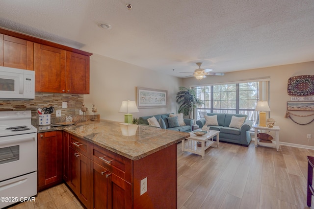 17462 Front Beach Rd Unit 55201, Panama City Beach, FL 32413 - kitchen featuring white appliances, backsplash, a peninsula, light stone countertops, and a textured ceiling