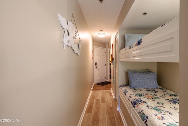 bedroom featuring light wood finished floors and baseboards