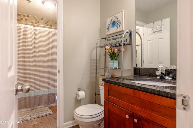 full bathroom featuring toilet, wood finished floors, vanity, a shower with shower curtain, and a textured ceiling