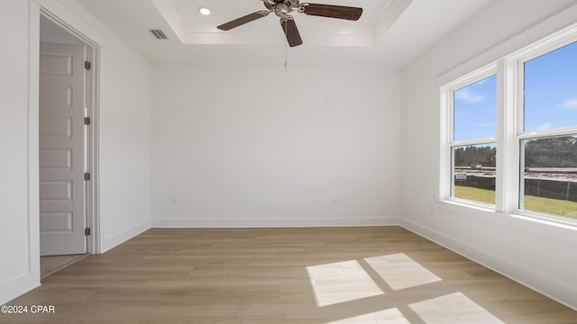 unfurnished room featuring a raised ceiling, light wood-style floors, a ceiling fan, baseboards, and recessed lighting