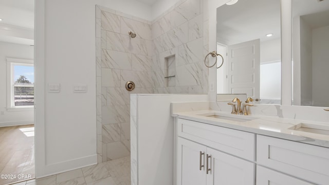 bathroom featuring a marble finish shower, baseboards, double vanity, marble finish flooring, and recessed lighting