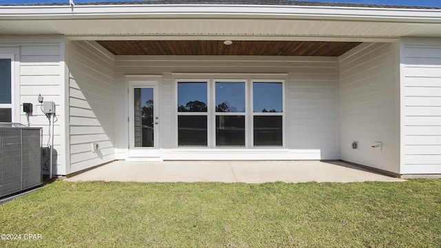 property entrance featuring central AC unit, a patio area, and a yard