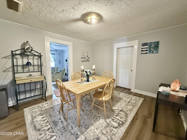 1331 Jackson Ave, Chipley, FL 32428 - dining space featuring wood finished floors, a textured ceiling, and baseboards