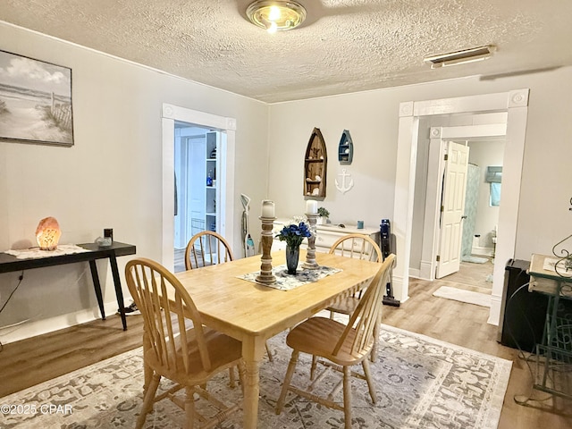 1331 Jackson Ave, Chipley, FL 32428 - dining room with light wood finished floors, a textured ceiling, and baseboards