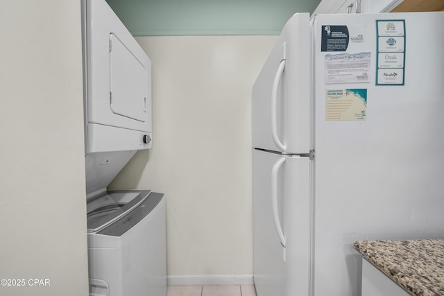 520 Richard Jackson Blvd Unit 703, Panama City Beach, FL 32407 - washroom with stacked washing machine and dryer, light tile patterned flooring, and baseboards