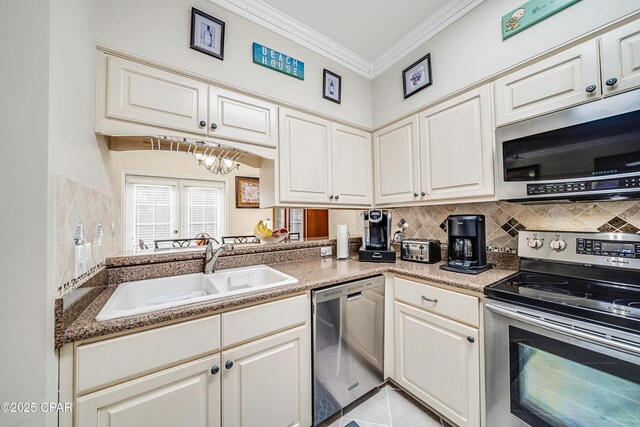 kitchen featuring appliances with stainless steel finishes, a sink, crown molding, backsplash, and a chandelier