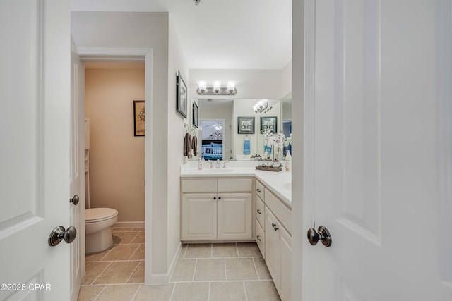 full bathroom featuring toilet, double vanity, tile patterned flooring, and connected bathroom