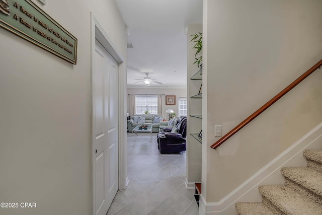 stairs with ceiling fan, tile patterned floors, baseboards, and crown molding