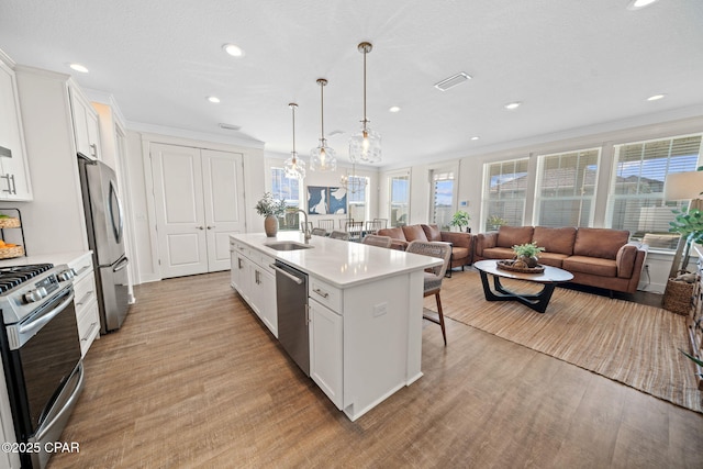 1009 N Discovery Loop, Panama City, FL 32405 - kitchen with stainless steel appliances, a sink, light countertops, a kitchen bar, and a kitchen island with sink