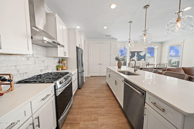 1009 N Discovery Loop, Panama City, FL 32405 - kitchen with wall chimney range hood, stainless steel appliances, a sink, light countertops, and decorative backsplash
