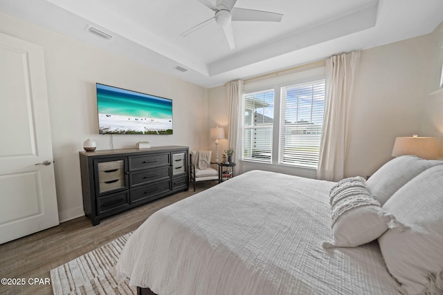 1009 N Discovery Loop, Panama City, FL 32405 - bedroom featuring a tray ceiling, wood finished floors, ceiling fan, and baseboards