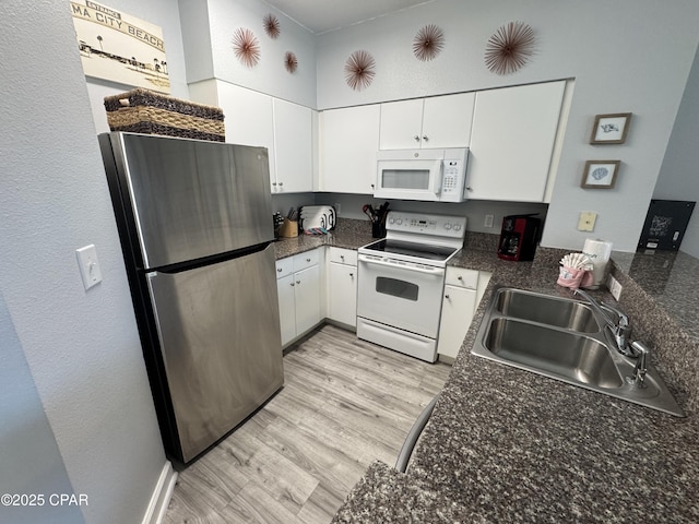 9900 S Thomas Dr Unit 2023, Panama City Beach, FL 32408 - kitchen with white appliances, a sink, white cabinets, and light wood-style flooring