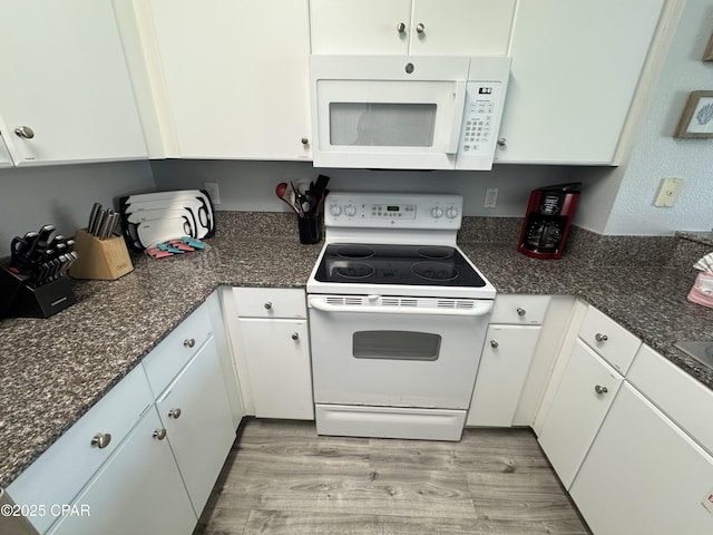 9900 S Thomas Dr Unit 2023, Panama City Beach, FL 32408 - kitchen with white appliances, white cabinets, and light wood finished floors