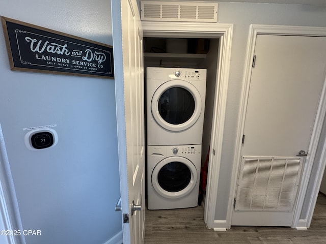 9900 S Thomas Dr Unit 2023, Panama City Beach, FL 32408 - laundry area with stacked washer and clothes dryer, wood finished floors, and baseboards