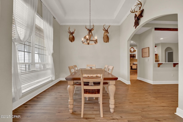 1104 Zephyr, Panama City, FL 32404 - dining room with wood finished floors, a chandelier, arched walkways, baseboards, and ornamental molding