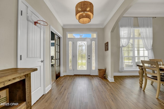1104 Zephyr, Panama City, FL 32404 - entrance foyer with arched walkways, baseboards, a chandelier, wood finished floors, and crown molding