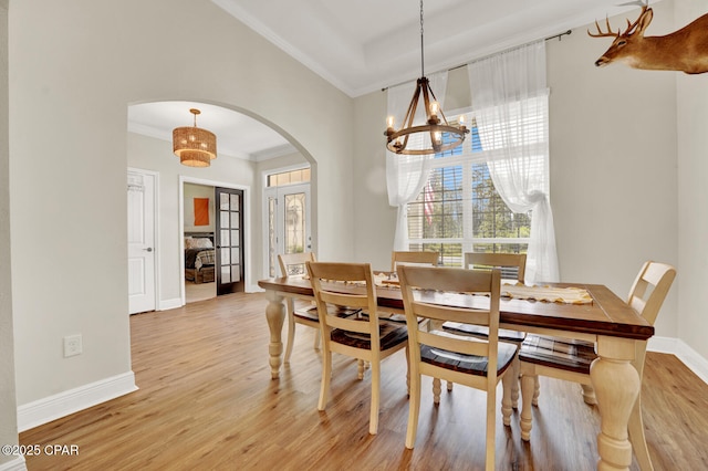 1104 Zephyr, Panama City, FL 32404 - dining space with arched walkways, ornamental molding, a chandelier, light wood finished floors, and baseboards